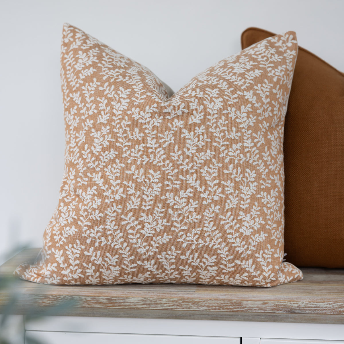 Wychwood Ginger Leaf Cushion with trailing cream leaves on a warm ginger background